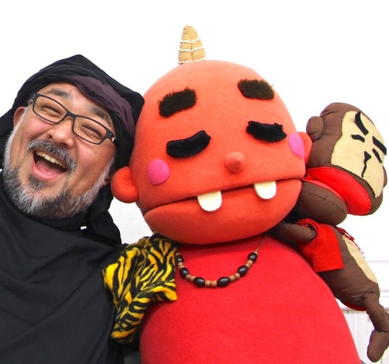 くまひげ先生こと鈴木幸一が、パペットとともに笑っている様子